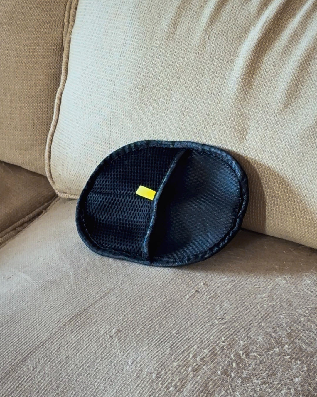 Furniture mitt lifting pet hair off a beige couch