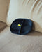 PawGroom furniture mitt on a beige sofa — mesh side with yellow tab
